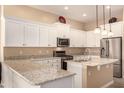 Modern kitchen with white cabinets, granite countertops, and stainless steel appliances at 2049 N 88Th St, Mesa, AZ 85207