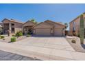 Three-car garage and nicely landscaped front yard highlight this home at 20767 N Bustos Way, Maricopa, AZ 85138