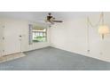 Living room featuring carpet flooring, large window and ceiling fan at 2442 N 22Nd Ave, Phoenix, AZ 85009