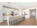 Well-equipped eat-in kitchen featuring stainless steel appliances, an island bar, and pendant lighting at 25948 W Sands Dr, Buckeye, AZ 85396