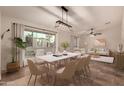 Elegant dining room with a modern chandelier and views of the backyard at 302 E Coral Gables Dr, Phoenix, AZ 85022