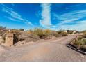 Scenic driveway leading to the property with desert landscaping, and address marker at 50031 N 27Th Ave, New River, AZ 85087