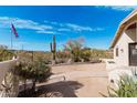 Inviting outdoor area with mature landscaping, desert views, a flag and decorative details at 50031 N 27Th Ave, New River, AZ 85087