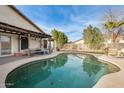 Inviting kidney-shaped pool with a covered patio area at 12858 W Wilshire Dr, Avondale, AZ 85392