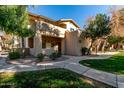 Exterior view of the condo featuring a well-maintained stucco facade, manicured landscaping and a walkway leading to the entrance at 1351 N Pleasant Dr # 1102, Chandler, AZ 85225