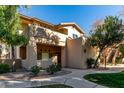 Exterior view of the condo featuring a well-maintained stucco facade, manicured landscaping and a walkway leading to the entrance at 1351 N Pleasant Dr # 1102, Chandler, AZ 85225
