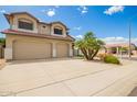 Tan home featuring a three-car garage, desert landscaping, and a red tile roof at 19520 N 65Th Ave, Glendale, AZ 85308