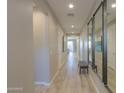 Inviting hallway featuring wood look tile and designer mirror and bench at 19920 N Wilford Ave, Maricopa, AZ 85138