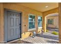 Front porch with gray door, two windows, and decorative lanterns at 2404 E Gillcrest Rd, Gilbert, AZ 85298