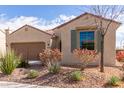 Tan house with two-car garage, featuring drought-resistant landscaping at 5575 W Cinder Brook Way, Florence, AZ 85132