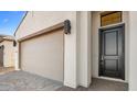 Modern garage and entryway with a dark brown door at 641 E Greenback Dr, San Tan Valley, AZ 85140