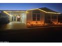 Charming single-Gathering home with a covered parking area, landscape, and warm lighting at twilight at 650 N Hawes Rd # 2713, Mesa, AZ 85207