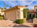 Two car garage in a neutral color with a tile roof and manicured landscaping at 10050 E Mountainview Lake Dr # 39, Scottsdale, AZ 85258