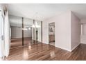 Dining area with hardwood floors and a mirrored wall reflecting the adjacent living space at 10437 W Caron Dr, Sun City, AZ 85351