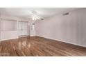 Bright living room with light pink walls and hardwood floors, featuring a ceiling fan at 10437 W Caron Dr, Sun City, AZ 85351