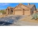 Exterior showcasing a house with a tan facade, tiled roof, and a spacious three-car garage at 11222 E Oberlin Way, Scottsdale, AZ 85262