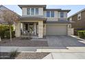 Inviting two-story home boasts neutral tones, low-maintenance landscaping, and a welcoming covered porch at 14369 W Wethersfield Rd, Surprise, AZ 85379