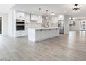 Bright kitchen featuring white cabinets, a center island, and hardwood floors at 17831 N 130Th Ave, Sun City West, AZ 85375