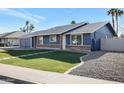 Newly renovated home with a blue exterior, brick accents, and a landscaped yard at 1845 E Hampton Ave, Mesa, AZ 85204