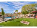 Landscaped backyard with a pool, patio furniture, and artificial turf at 19410 N 77Th Dr, Glendale, AZ 85308