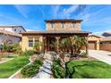 Inviting home with a covered porch framed by wooden beams and complemented by lush, manicured landscaping at 20620 W Walton Dr, Buckeye, AZ 85396