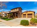 Beautiful two-story home with stone accents, covered front porch, and a well-manicured lawn at 20620 W Walton Dr, Buckeye, AZ 85396