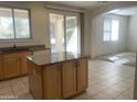 Bright kitchen featuring a center island, granite counters, and an open layout to the dining area at 2113 E Sunland Ave, Phoenix, AZ 85040