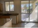 Kitchen with a view to the backyard, sliding glass doors, and a white dishwasher at 2113 E Sunland Ave, Phoenix, AZ 85040