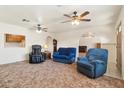 Spacious living room featuring two blue armchairs and a massage chair at 3432 N 86Th Ave, Phoenix, AZ 85037