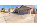 Tan house with a two-car garage and a wooden gate at 4213 E Stanford Ave, Gilbert, AZ 85234