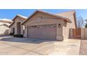 Tan house with a two-car garage and a wooden gate at 4213 E Stanford Ave, Gilbert, AZ 85234