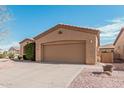 Front view of a tan house with a two-car garage at 5077 S Barley Way, Gilbert, AZ 85298