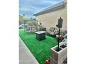 Cozy backyard patio featuring modern outdoor furniture and lush synthetic grass at 5131 W Fairview St, Chandler, AZ 85226