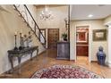 Elegant foyer featuring tiled flooring, chandelier, staircase, and antique furniture at 7500 E Mccormick Pkwy # 19, Scottsdale, AZ 85258