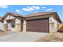 Attractive single-story home featuring a two-car garage, stone accents, and desert landscaping at 7548 W Park St, Laveen, AZ 85339