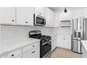 Modern kitchen featuring white cabinets, subway tile backsplash, and stainless steel appliances at 7548 W Park St, Laveen, AZ 85339