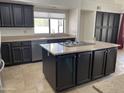 Modern kitchen with dark cabinets, granite counters, and an island at 8028 E La Junta Rd, Scottsdale, AZ 85255