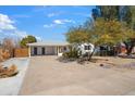 Front view of a house with a driveway and mature trees at 8344 E Indianola Ave, Scottsdale, AZ 85251