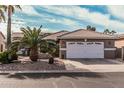 Exterior view of the home's garage with an automatic door, mature landscaping, and tile roof at 10139 E Copper Dr, Sun Lakes, AZ 85248