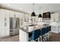 Modern kitchen features stainless steel appliances, a large island with seating, and white cabinets at 14701 W Sentinel Dr, Sun City West, AZ 85375