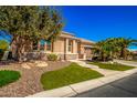 Beautiful single-story home with stone accents, landscaped yard, green lawn, and palm trees at 16442 W Berkeley Rd, Goodyear, AZ 85395