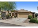 Attractive home with a spacious driveway, a two-car garage, and desert landscaping creating a serene environment at 17750 W Watson Ln, Surprise, AZ 85388