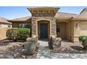 Welcoming front entrance with a stone-accented porch and a well-maintained yard offering a warm first impression at 17750 W Watson Ln, Surprise, AZ 85388
