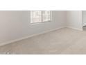 Cozy bedroom featuring neutral carpeting, a window with blinds, and fresh paint at 17875 W Getty Dr, Goodyear, AZ 85338