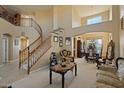 Spacious living room features a winding staircase, high ceilings, neutral paint, and carpet flooring at 18017 W Desert Ln, Surprise, AZ 85388
