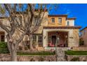 Charming two-story home with a welcoming front porch, landscaping, and terra cotta roof tiles at 21134 W Sunrise Ln, Buckeye, AZ 85396