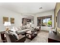 Bright living room boasts comfortable seating, a decorative rug and large window with outdoor views at 42017 N Crooked Stick Rd, Anthem, AZ 85086