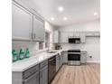 Modern kitchen boasts gray cabinets, quartz countertops, and stainless steel appliances at 4446 W Townley Ave, Glendale, AZ 85302