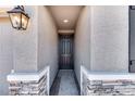 Home entryway featuring a dark wood door framed by stucco walls and stone accents at 9036 S 196Th Dr, Goodyear, AZ 85338