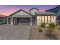 Two-story home with gray siding, brick accents, and a paved driveway at 11682 W Parkway Ln, Avondale, AZ 85323